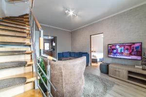 a living room with a staircase and a tv at Casa Stella - spacious central villa in Cluj-Napoca