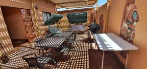 a balcony with tables and chairs on a building at Casa Chactur in San Pedro de Atacama