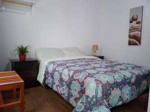 a bedroom with a bed with a colorful bedspread at Hotel Via Morburg in Nazca