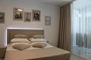 um quarto com uma cama com almofadas e uma janela em On Beach-Mamaia Residence em Mamaia Nord – Năvodari