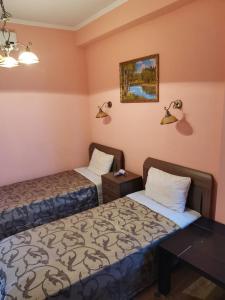 a room with two beds and a table and lamps at Guesthouse Aragats in Adler