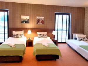 a bedroom with two beds and two windows at Hotel Willowa in Lublin