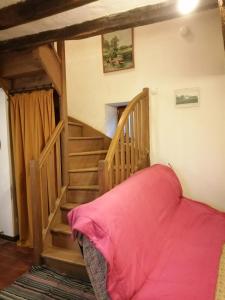 a room with a staircase with a pink bed in it at La maison de Xenos in Nohant-en-Graçay