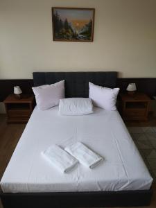 a large white bed with two towels on it at Hotel Duka in Warsaw