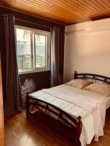 1 cama en un dormitorio con ventana en Le Chalet Kréol, en Saint-Joseph