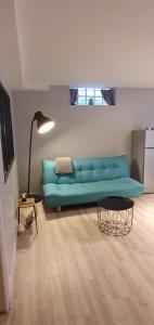 ein Wohnzimmer mit einem blauen Sofa und einem Tisch in der Unterkunft Appartement RDC Centre Cabourg in Cabourg