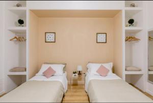 two beds in a room with white shelves at Charming 25 Apartment in Rome