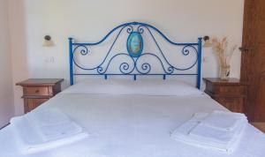 a bed with a blue headboard and two night stands at Rustico del Conero in Camerano