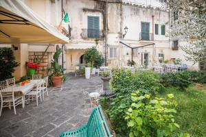 シラクーサにあるGli appartamenti di Locanda Nonna Ioleの屋外パティオ(テーブル、椅子、植物付)