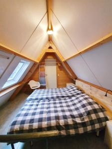a attic room with a bed in a house at Tuinhuis in Schagen
