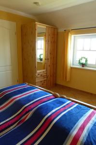 Schlafzimmer mit einem Bett und einem Fenster in der Unterkunft "Strand-Gut" in Börgerende-Rethwisch