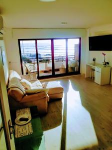 a living room with a couch and a large window at Porto Sea Apartments in Matosinhos