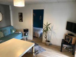 a living room with a couch and a bed in a room at Le Panier Fleuri in Lacanau