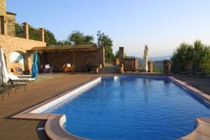 una piscina en un patio con terraza de madera en Castel Martino, en Cortemilia