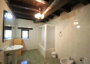 a large bathroom with a sink and a toilet at Casa Batit in Viscarret-Guerendiáin