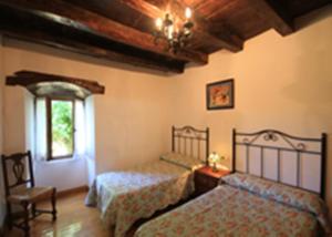 a bedroom with two beds and a window at Casa Batit in Viscarret-Guerendiáin