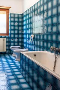 bagno piastrellato blu con 2 servizi igienici e vasca di Hostel - Bormio - Livigno - Santa Caterina - Stelvio a Sondalo