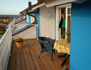 Eine Frau, die aus einem Fenster auf einem Deck schaut. in der Unterkunft "Strand-Gut" in Börgerende-Rethwisch