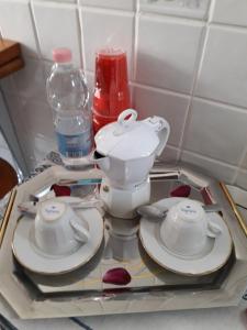 a tray with a tea pot and plates and a water bottle at Sweet Carola in Bari