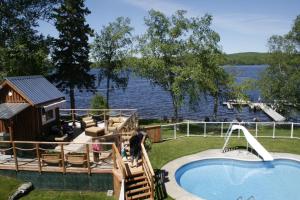 a resort with a swimming pool and a house at Auberge et Chalets sur le Lac in Lac-Mégantic