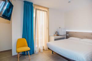 a bedroom with a bed and a yellow chair at Solesperit in Lloret de Mar