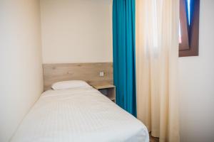 a small bed in a room with blue curtains at Solesperit in Lloret de Mar