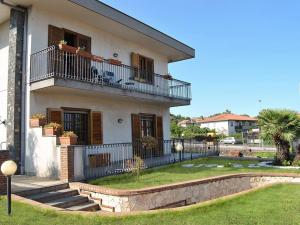 a white house with a balcony and a yard at I capricci dell'Etna 1 di Puglisi in Mascalucia