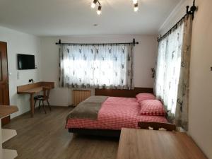 a bedroom with a bed with red sheets and a desk at Chalet Glockenhof in Walchsee