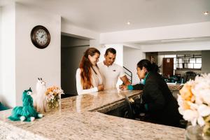 eine Gruppe von Menschen, die um einen Tresen stehen in der Unterkunft Muru Homely Hotel Cusco in Cusco