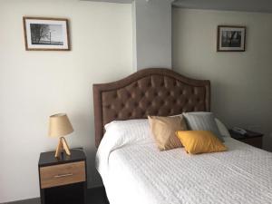 a bedroom with a bed with a yellow pillow on it at Nivial in Tacna