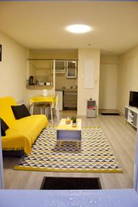 een woonkamer met een gele bank en een tafel bij Appart Chrystal in Carcassonne