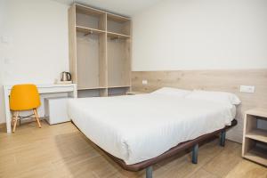 a bedroom with a bed and a desk and a chair at Solesperit in Lloret de Mar