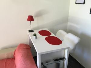 コゴランにあるStudio climatisé piscine parking - Prix du Voyageur 2023 et 2024 ! Merciのソファの横に赤いラグが敷かれた白いテーブル