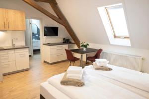 a room with two beds and a table with chairs at Lebererhof Apartments in Roßtal
