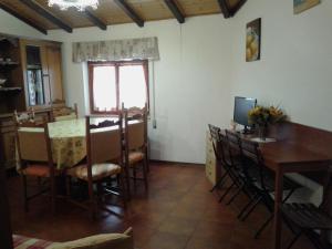 a dining room with a table and chairs and a television at Mansarda in montagna in Abetone