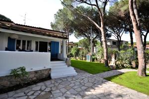 a white house with a pathway leading to a yard at Villa Montecristo in Marina di Campo