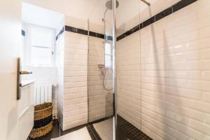 La salle de bains est pourvue d'une douche avec une porte en verre. dans l'établissement BLAISE RAYNAL #1 - Appartement coquet - 2 personnes, à Brive-la-Gaillarde