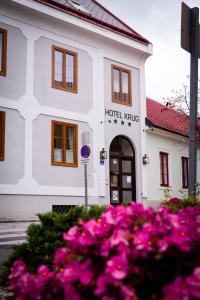 een hotelgebouw met roze bloemen ervoor bij Hotel Krug in Gumpoldskirchen