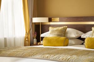 a bedroom with a bed with yellow and white pillows at Trinity Townhouse Hotel in Dublin