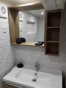 een badkamer met een witte wastafel en een spiegel bij CENTRE HISTORIQUE T3 DUPLEX PARKING Gratuit in Béziers +13 foto's