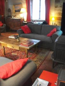 ein Wohnzimmer mit Sofas und einem Couchtisch in der Unterkunft La Maison des Gardes - Chambres d'hôtes in Cluny