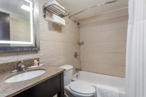 a bathroom with a sink and a toilet and a mirror at Travelodge by Wyndham South Hackensack in South Hackensack