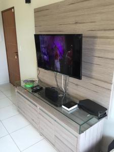 un centro de entretenimiento con TV de pantalla plana en la pared en Flat Condomínio Serra Negra en Bezerros