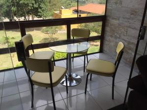a glass table and chairs on a balcony at Flat Condomínio Serra Negra in Bezerros