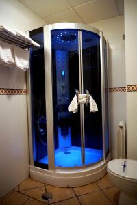 a glass shower in a bathroom with a toilet at Complejo turístico y alojamientos Fuente de la Salud in Baena
