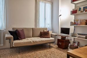 een woonkamer met een bank en een televisie bij Ca' Widmann in Venetië