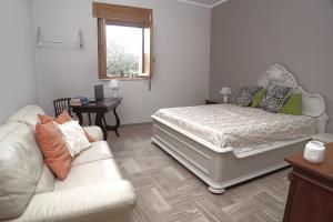 a bedroom with a bed and a couch at Villa Il Giovane Alloro in Martina Franca