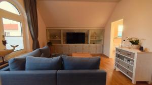 a living room with a blue couch and a tv at Haus Wopke in Borkum +8 photos