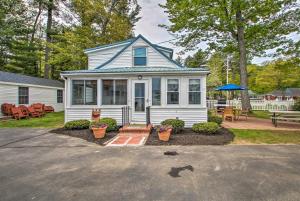 a white house with a blue roof and a patio at Sebago Lake Cottage with Patio and Beach Access! in North Sebago