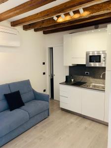 Apartment New Luxury Prince-Suite Venezia San Marco في البندقية: غرفة معيشة مع أريكة زرقاء في مطبخ